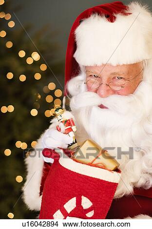 Portrait of Santa Claus holding nutcracker toy View Large Photo Image Picture - Portrait of Santa Claus holding nutcracker toy. Fotosearch