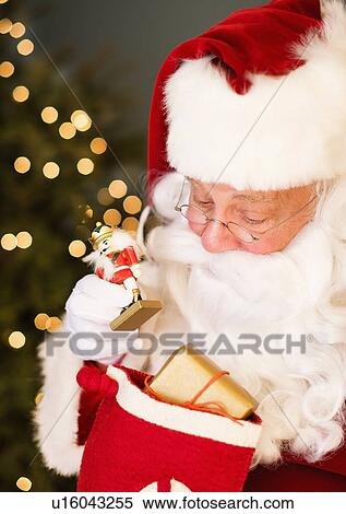 Stock Photography - Portrait of Santa Claus holding nutcracker toy. Fotosearch