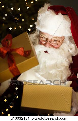 Portrait of Santa Claus opening Christmas presents View Large Photo Image Stock Image - Portrait of Santa Claus opening Christmas presents. Fotosearch