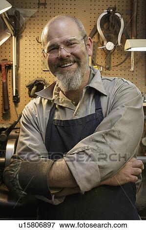 Portrait of smiling jeweler in workshop View Large Photo Image Stock Photo - Portrait of smiling jeweler in workshop. Fotosearch