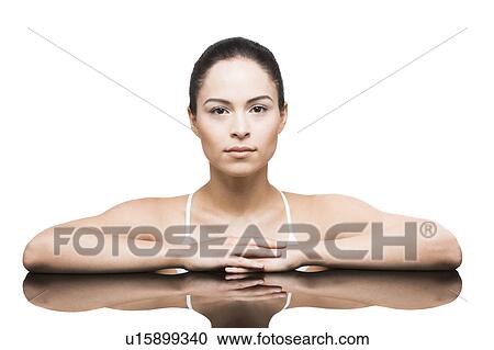 Stock Image - Portrait of woman leaning on mirror. Fotosearch