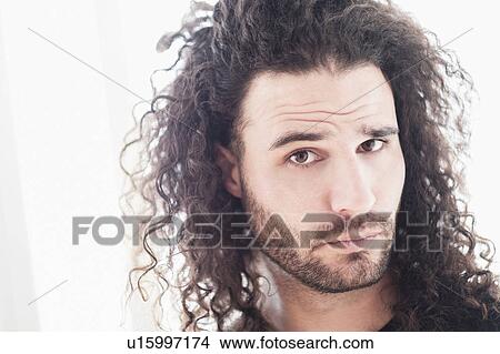 Picture - Portrait of young man with long curly hair. Fotosearch
