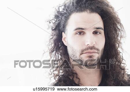 Stock Photo - Portrait of young man with long curly hair. Fotosearch