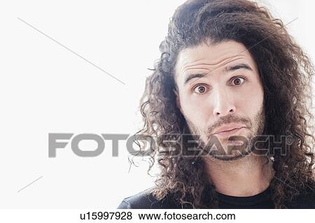 Stock Photo - Portrait of young man with long curly hair. Fotosearch