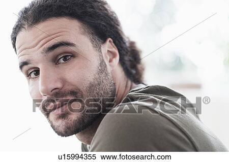 Stock Photography - Portrait of young man with long curly hair. Fotosearch