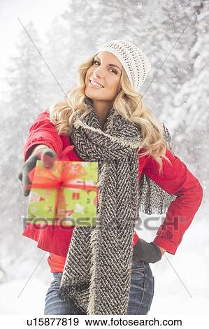 Portrait of young woman holding Christmas present View Large Photo Image Stock Photo - Portrait of young woman holding Christmas present. Fotosearch