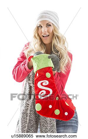 Stock Photography - Portrait of young woman holding Christmas stocking. Fotosearch