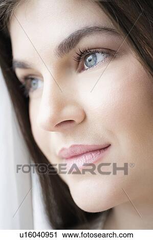 Stock Image - Portrait of young woman with brown hair. Fotosearch