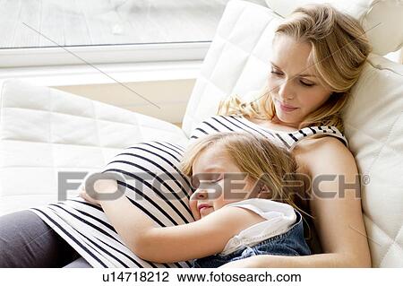 Stock Image - Pregnant mother and daughter resting. Fotosearch