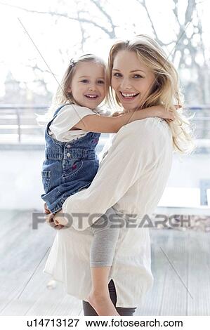 Stock Photo - Pregnant mother lifting Girl. Fotosearch