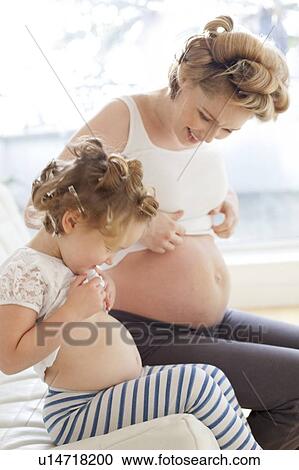 Stock Image - Pregnant woman and daughter. Fotosearch
