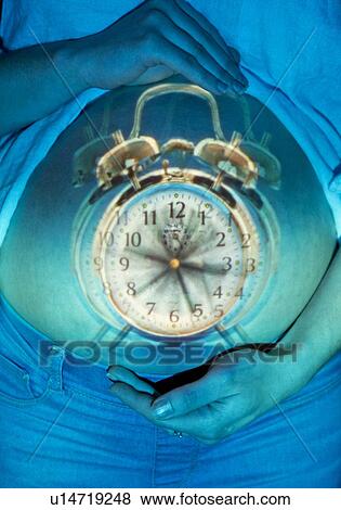 Pregnant woman holding alarm clock View Large Photo Image Stock Photo - Pregnant woman holding alarm clock. Fotosearch