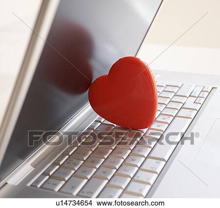 Picture - Red heart on laptop computer. Fotosearch