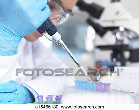 Stock Image - Researcher pipetting liquid. Fotosearch