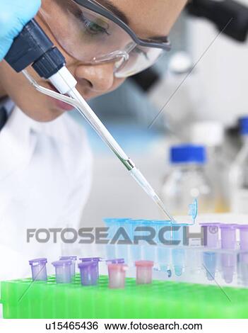 Stock Photograph - Researcher pipetting liquid. Fotosearch