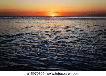 Stock Image - Romantic sunset over sea. Fotosearch