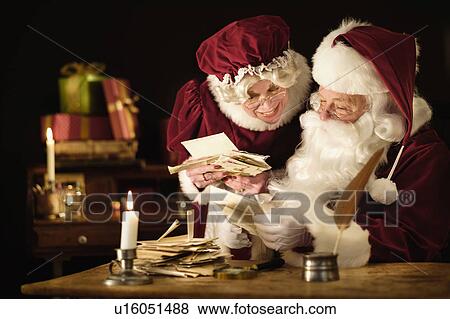Stock Photo - Santa and Mrs. Claus reading child's letter. Fotosearch