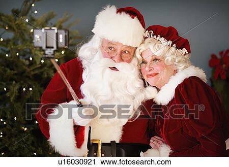 Santa and Mrs. Santa taking selfie with monopod View Large Photo Image Stock Image - Santa and Mrs. Santa taking selfie with monopod. Fotosearch