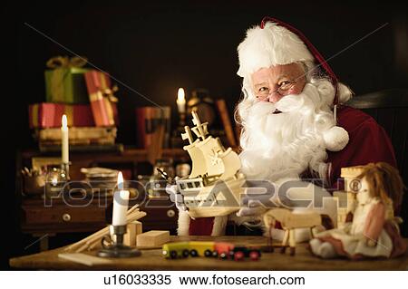 Stock Photography - Santa Claus making wooden toy. Fotosearch