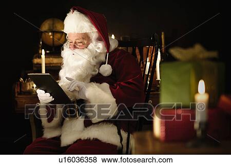 Santa Claus using digital tablet View Large Photo Image Stock Photo - Santa Claus using digital tablet. Fotosearch