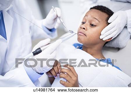 Scared boy looking at dental drill View Large Photo Image Picture - Scared boy looking at dental drill. Fotosearch