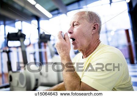 Stock Image - Senior man using inhaler. Fotosearch