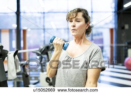 Stock Photo - Senior woman holding dumbbell. Fotosearch