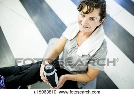 Stock Image - Senior woman holding water bottle. Fotosearch