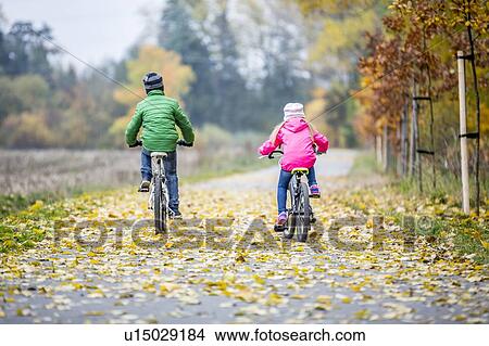 Siblings cycling together View Large Photo Image Picture - Siblings cycling together. Fotosearch