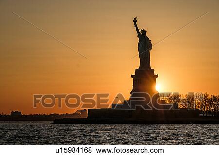 Stock Photo - Silhouette of Statue of Liberty at sunset. Fotosearch