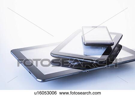Stock Photograph - Smart phone lying on digital tablets. Fotosearch