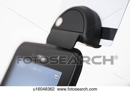 Stock Image - Smart phone with credit card reader. Fotosearch