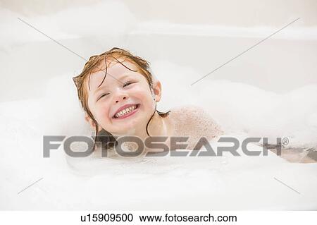 Stock Image - Smiling girl (4-5) having bubble bath. Fotosearch