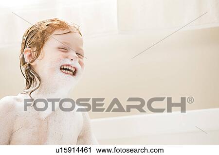 Stock Image - Smiling girl (4-5) having bubble bath. Fotosearch
