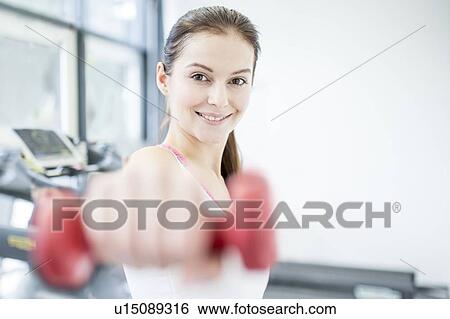 Smiling young woman holding dumbbell View Large Photo Image Stock Photograph - Smiling young woman holding dumbbell. Fotosearch