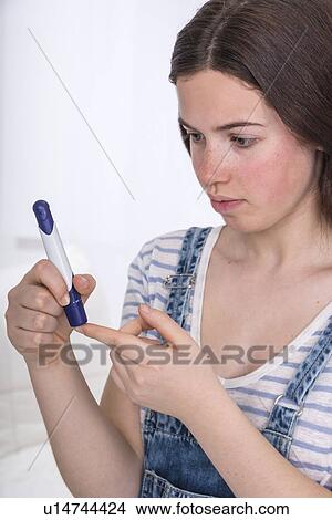 Teenage girl doing a finger prick test View Large Photo Image Picture - Teenage girl doing a finger prick test. Fotosearch