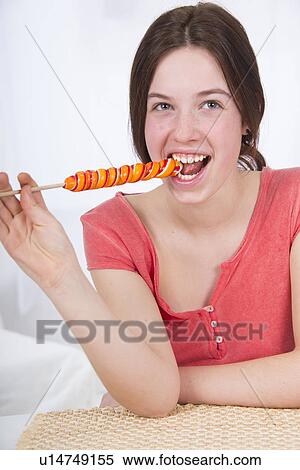 Teenage girl eating lollipop View Large Photo Image Stock Photography - Teenage girl eating lollipop. Fotosearch
