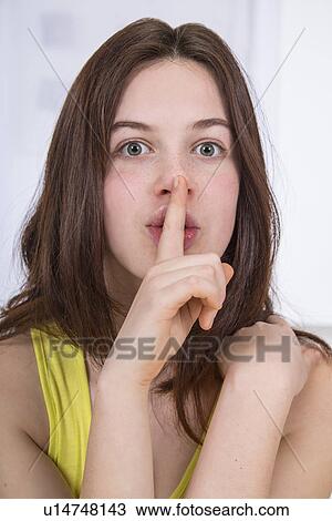 Teenage girl with finger on lips View Large Photo Image Stock Image - Teenage girl with finger on lips. Fotosearch