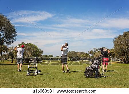 Three men playing golf View Large Photo Image Stock Image - Three men playing golf. Fotosearch