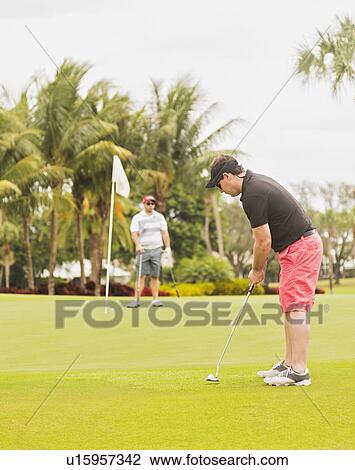 Two men playing golf View Large Photo Image Stock Image - Two men playing golf. Fotosearch