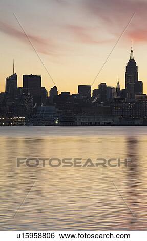 Waterfront with city skyline at dawn View Large Photo Image Stock Photograph - Waterfront with city skyline at dawn. Fotosearch
