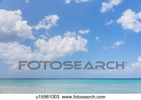 Stock Image - White clouds over tropical sea. Fotosearch