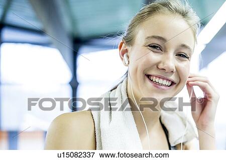 Stock Photo - Woman adjusting headphones. Fotosearch