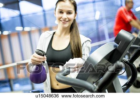 Woman cleaning exercise bike View Large Photo Image Stock Photograph - Woman cleaning exercise bike. Fotosearch