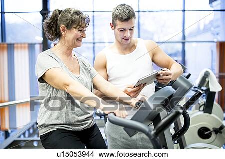 Picture - Woman exercising with trainer. Fotosearch