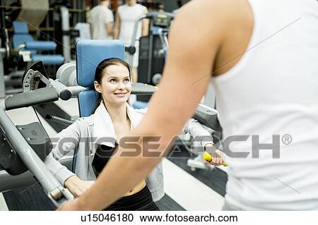 Stock Image - Woman exercising with trainer. Fotosearch