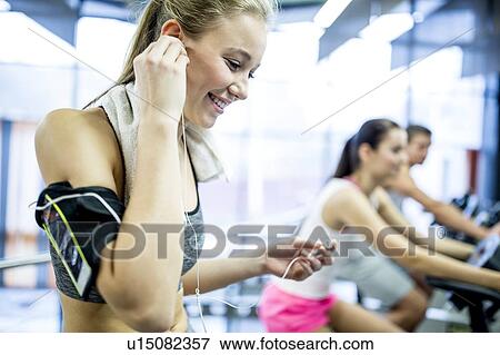 Woman inserting headphones View Large Photo Image Stock Photo - Woman inserting headphones. Fotosearch