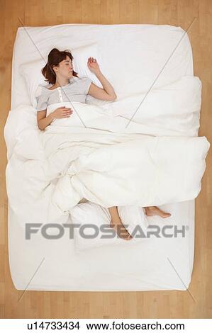 Woman lying in bed, asleep View Large Photo Image Picture - Woman lying in bed, asleep. Fotosearch