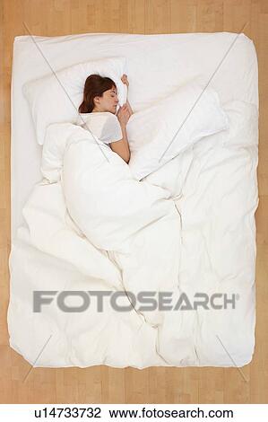 Woman lying in bed, asleep View Large Photo Image Stock Image - Woman lying in bed, asleep. Fotosearch