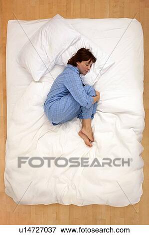 Woman lying in bed, asleep View Large Photo Image Stock Photo - Woman lying in bed, asleep. Fotosearch